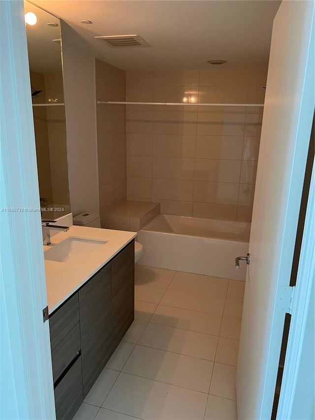 full bathroom with toilet, tiled shower / bath combo, vanity, and tile patterned flooring