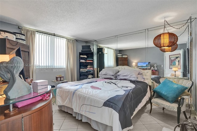 bedroom featuring light tile patterned floors and a textured ceiling