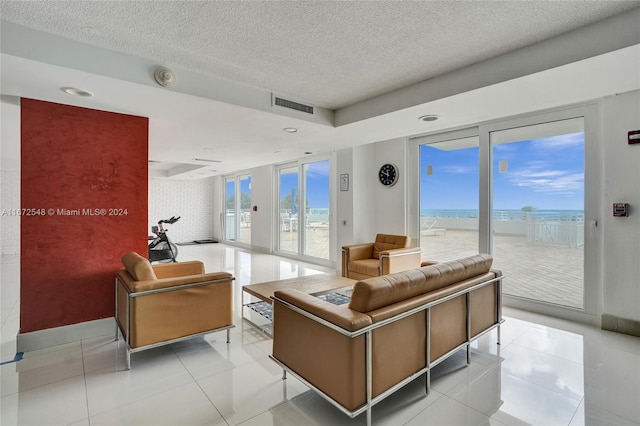 living room featuring light tile patterned floors, a textured ceiling, and a water view