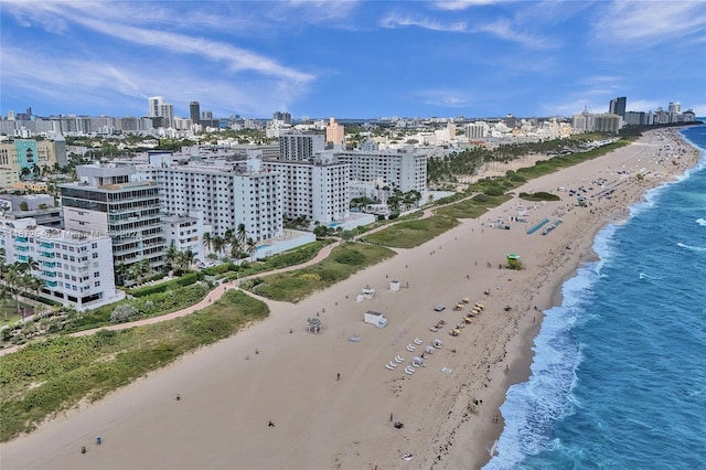 drone / aerial view featuring a water view and a beach view