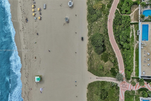 birds eye view of property with a water view and a view of the beach