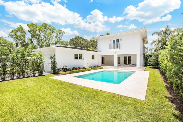 back of property featuring a lawn, a balcony, and a patio