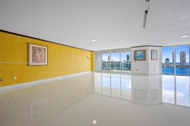 spare room featuring tile patterned flooring and expansive windows