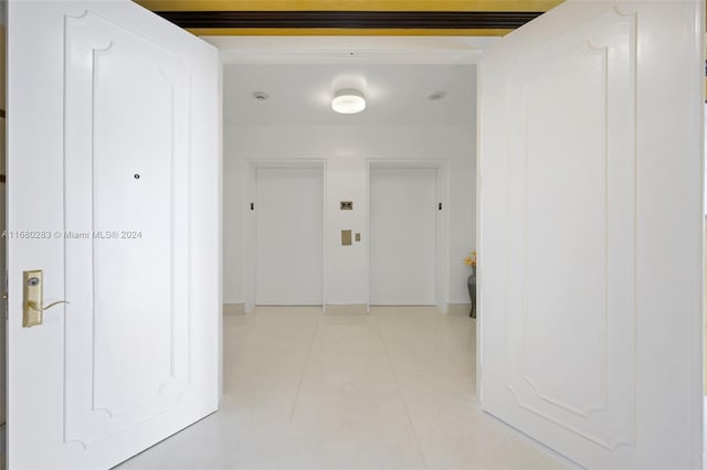 hall with elevator and light tile patterned floors