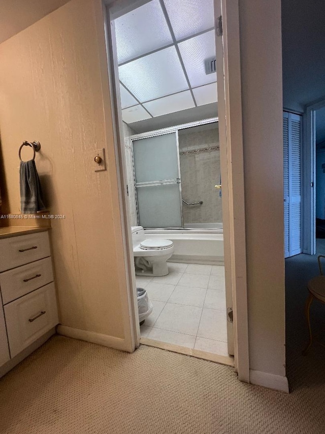 full bathroom with tile patterned floors, toilet, a paneled ceiling, vanity, and shower / bath combination with glass door