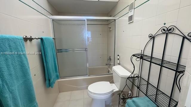 bathroom with toilet and enclosed tub / shower combo