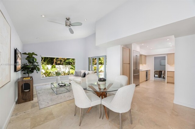 dining space with ceiling fan and high vaulted ceiling