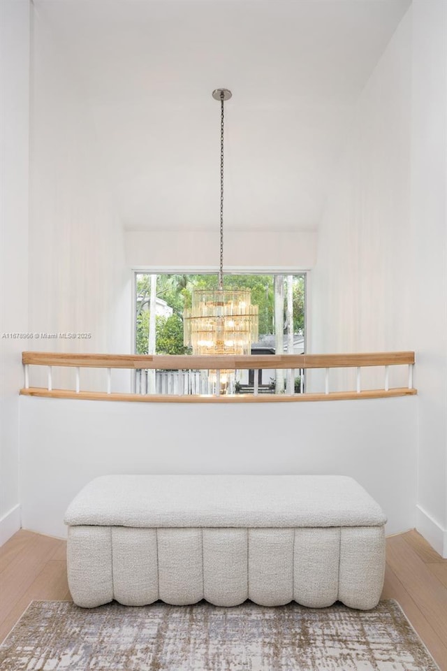 living area with wood-type flooring, a wealth of natural light, and an inviting chandelier