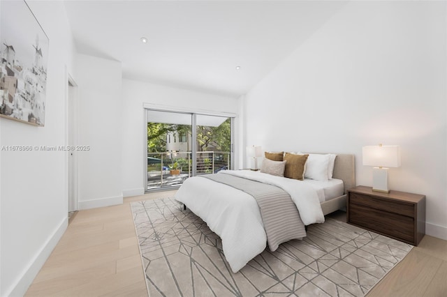 bedroom featuring vaulted ceiling, access to exterior, and light hardwood / wood-style floors