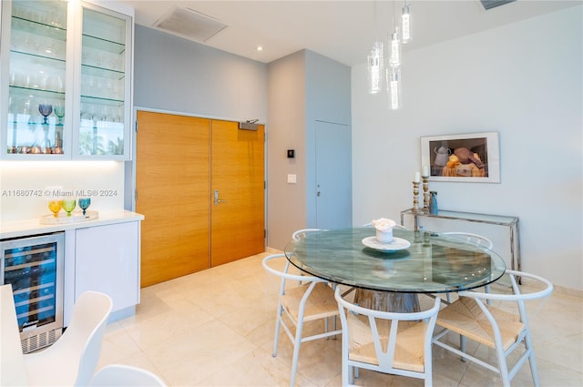 dining room with light tile patterned flooring, indoor bar, and beverage cooler