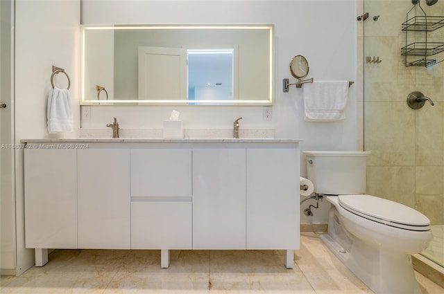 bathroom featuring vanity, a tile shower, toilet, and tile patterned flooring