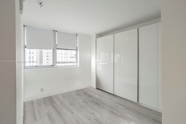 unfurnished bedroom with a closet and light hardwood / wood-style floors