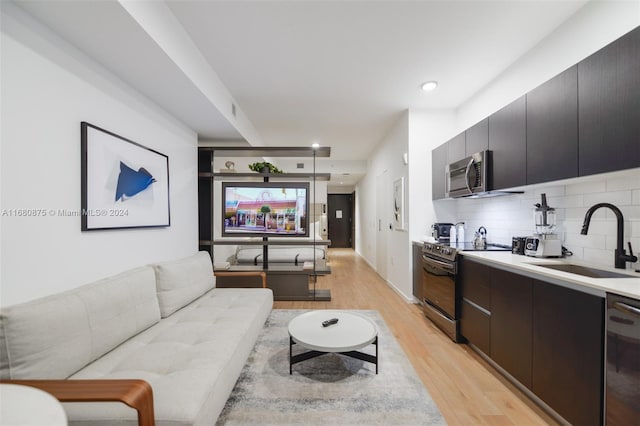 living room with light hardwood / wood-style floors and sink