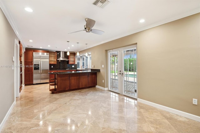 kitchen featuring french doors, wall chimney range hood, hanging light fixtures, ornamental molding, and stainless steel built in refrigerator