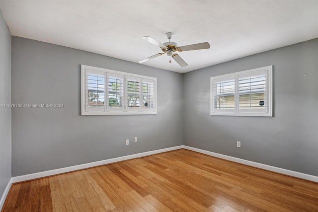 spare room with ceiling fan, plenty of natural light, and hardwood / wood-style floors