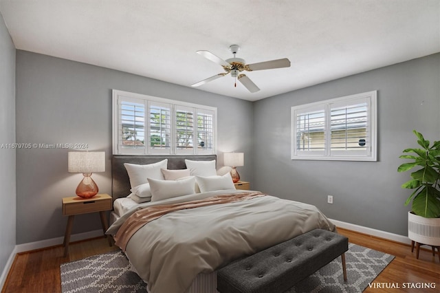 bedroom featuring dark wood-type flooring, multiple windows, and ceiling fan