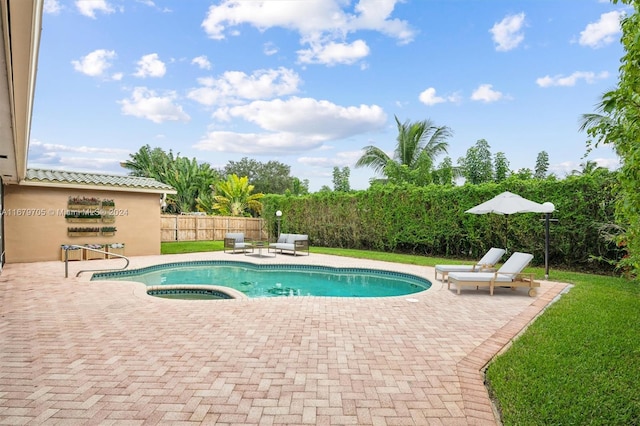 view of pool with a patio area, an in ground hot tub, and a lawn