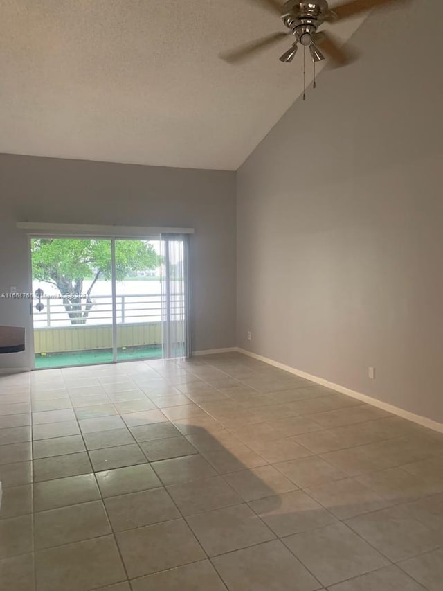 spare room with ceiling fan, light tile patterned floors, a textured ceiling, and high vaulted ceiling