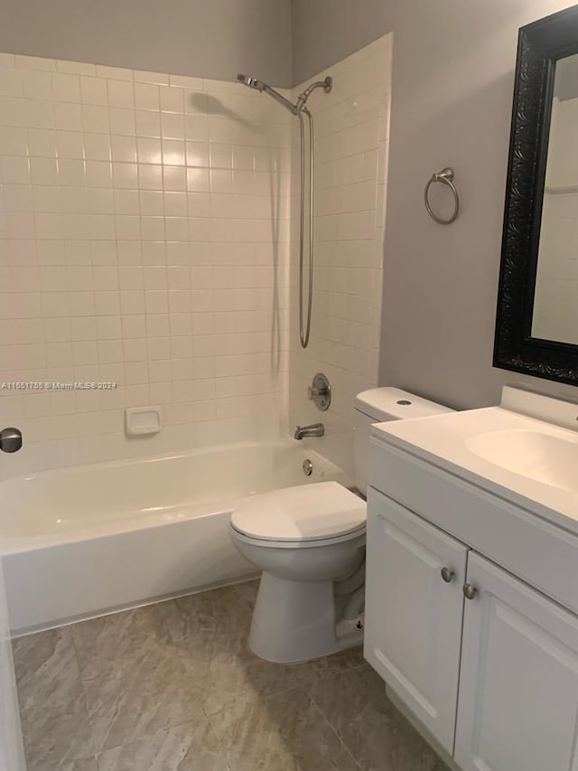 full bathroom featuring vanity, tiled shower / bath combo, and toilet