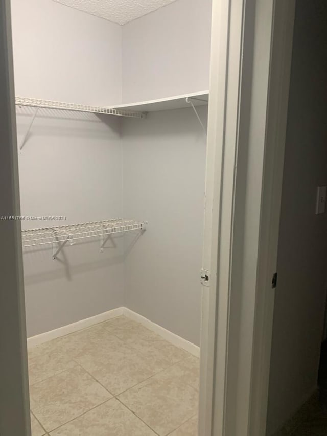 walk in closet with light tile patterned floors