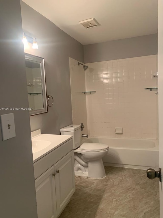 full bathroom featuring tiled shower / bath combo, toilet, and vanity