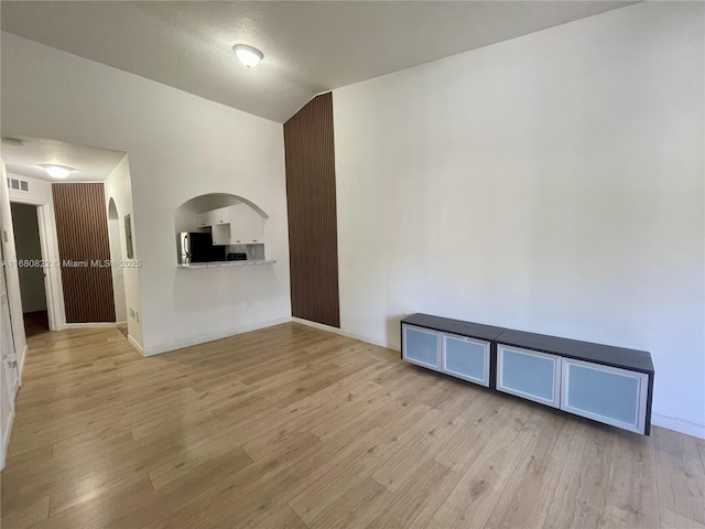 spare room featuring light hardwood / wood-style flooring and a textured ceiling