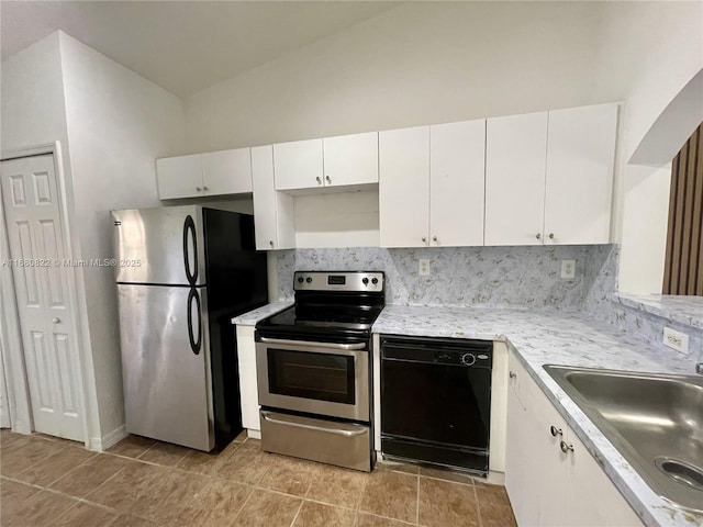 kitchen featuring lofted ceiling, backsplash, white cabinets, sink, and stainless steel appliances