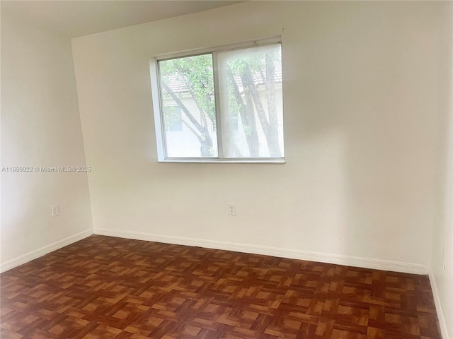 spare room featuring dark parquet floors