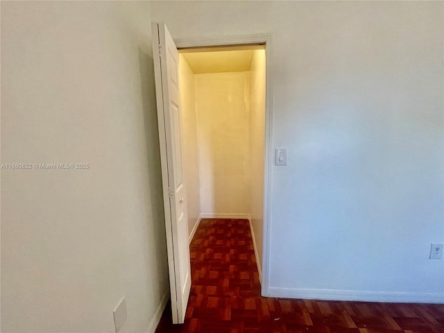 corridor featuring dark parquet flooring