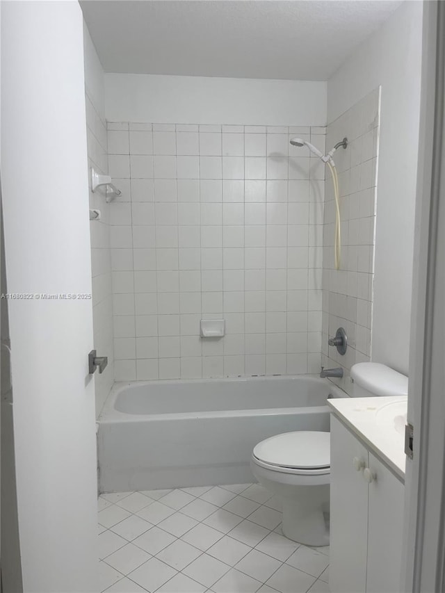 full bathroom with tiled shower / bath, tile patterned flooring, vanity, and toilet