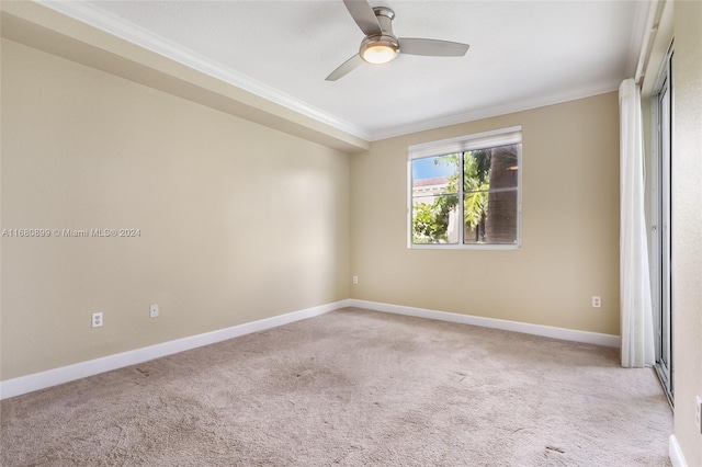 carpeted empty room featuring ornamental molding and ceiling fan