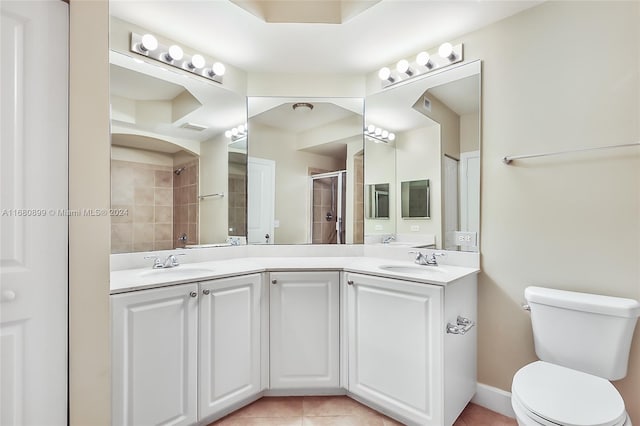 bathroom with vanity, toilet, a shower with shower door, and tile patterned flooring