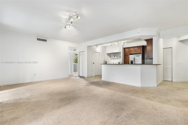 unfurnished living room with light carpet, crown molding, and rail lighting