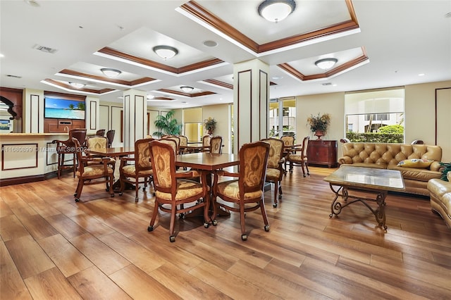 dining area with ornate columns, coffered ceiling, and light hardwood / wood-style flooring