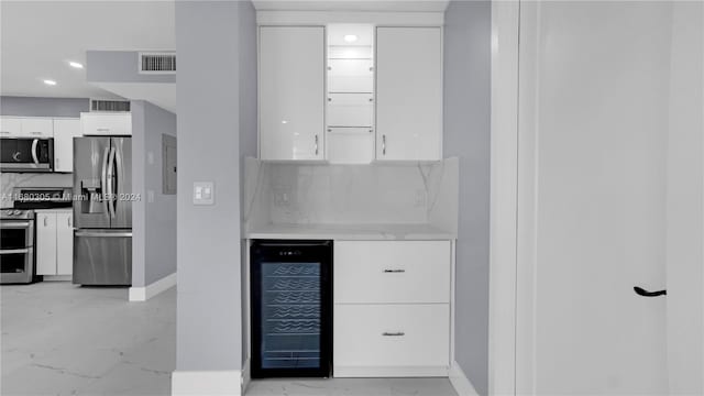 kitchen featuring stainless steel appliances, backsplash, wine cooler, electric panel, and white cabinetry