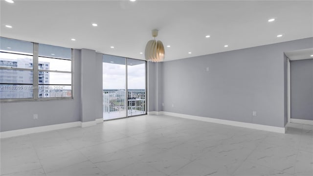 unfurnished room featuring a wall of windows