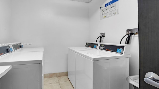 laundry room with washer and dryer and light tile patterned floors