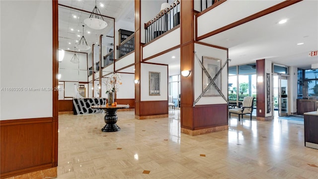 interior space with parquet floors, a towering ceiling, and wooden walls