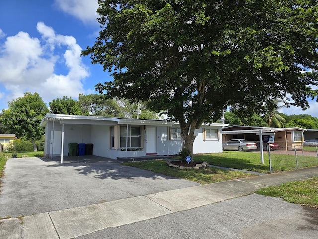 ranch-style home featuring a front lawn and a carport