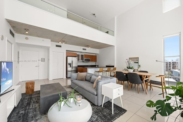 living room featuring a high ceiling and light tile patterned floors