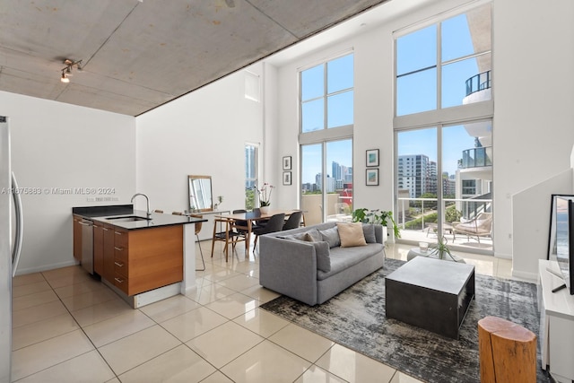 living room with light tile patterned floors, sink, and a high ceiling