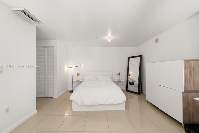 tiled bedroom featuring a closet and an AC wall unit