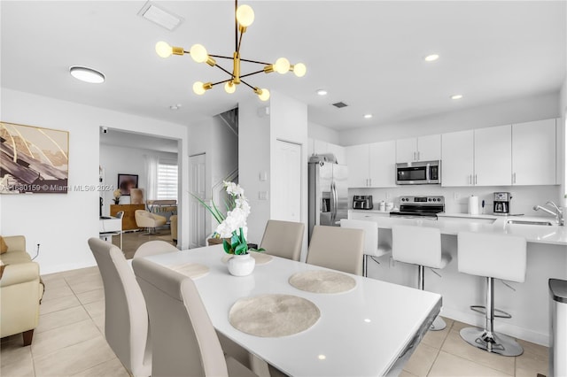 dining room with light tile patterned floors, sink, and a chandelier