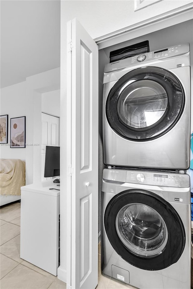 laundry room with stacked washing maching and dryer and light tile patterned flooring