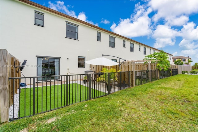 rear view of property featuring a lawn