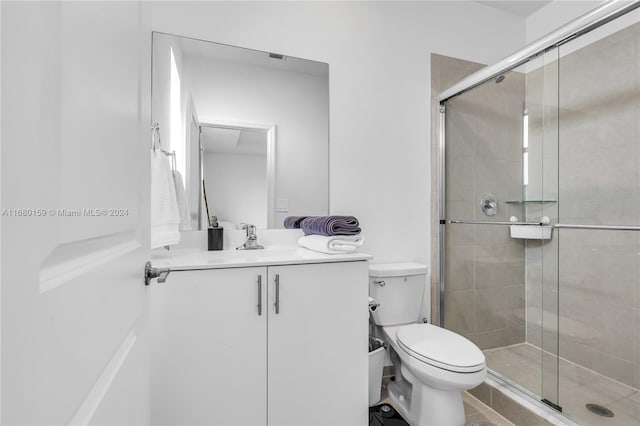 bathroom with toilet, an enclosed shower, and vanity