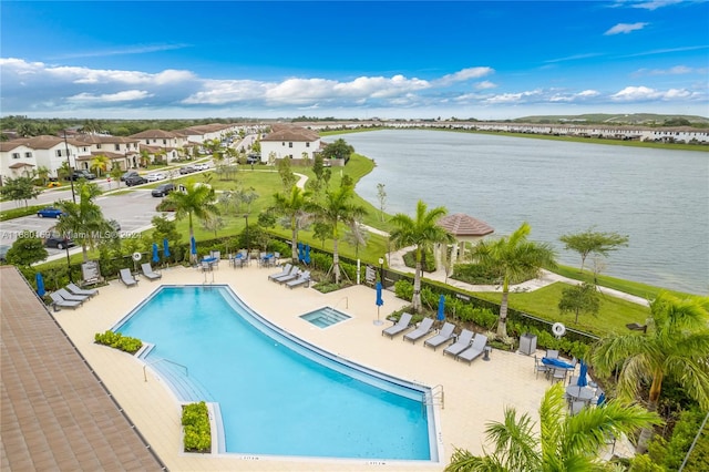 view of swimming pool with a water view and a patio area