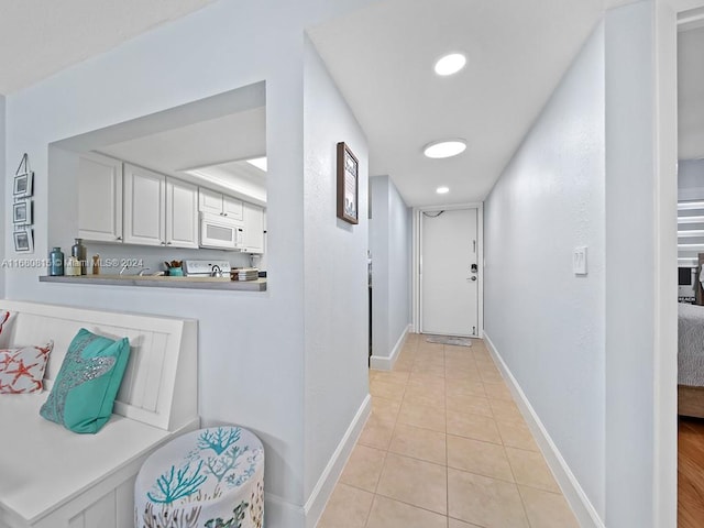 hall with light tile patterned floors