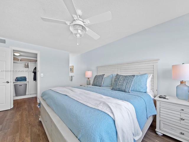 bedroom featuring dark hardwood / wood-style flooring, ceiling fan, and a closet