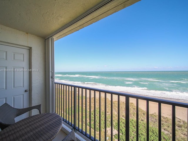 balcony featuring a water view and a view of the beach